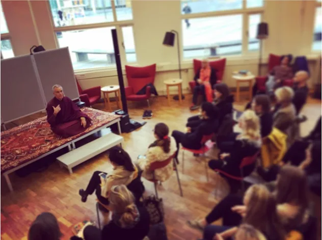 Buddhist monk teaching a group of lay students